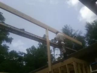 Carpenter setting a ridge beam over a new addition frame — Ice Dam Removal by Roofing Brothers in Rowan