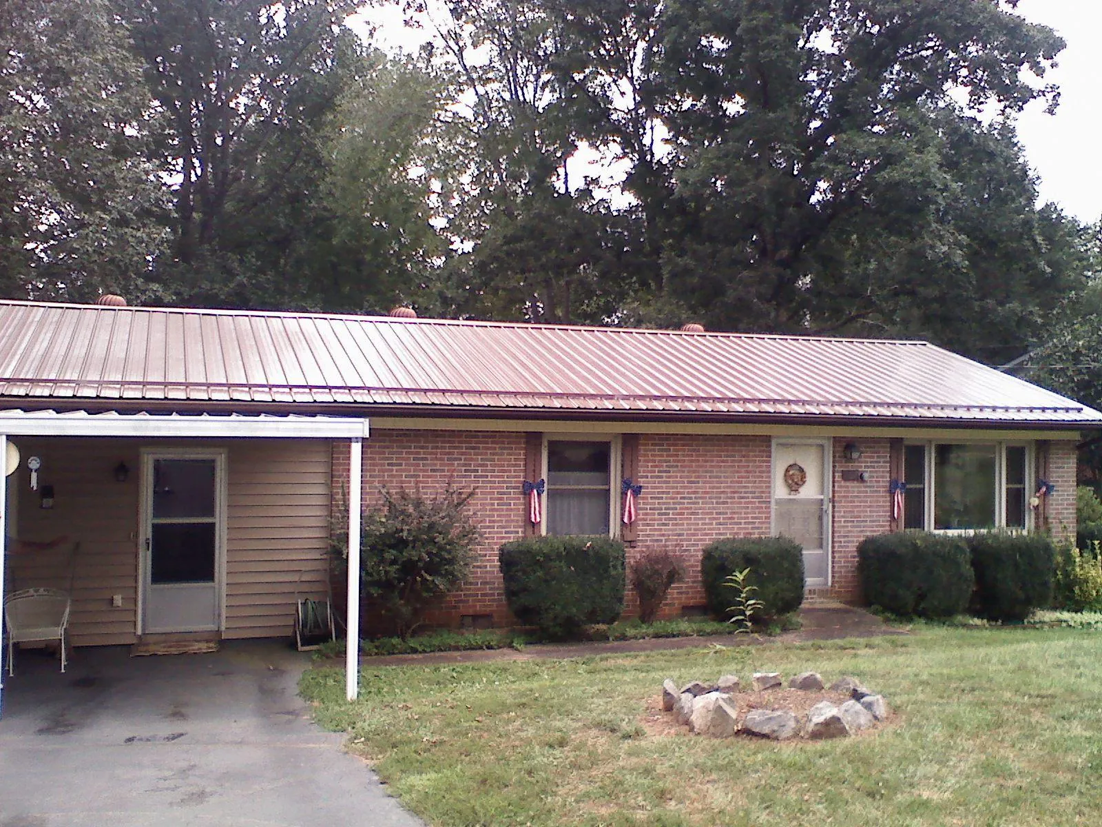 Bronze metal roof and carport on a brick ranch home — Roof Repair work by our crew in Rowan