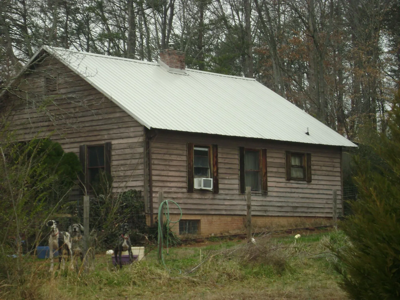 White metal roof on an old wood sided farmhouse, from a Metal Roof Installation job in Rowan